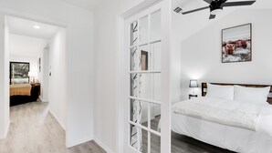 A bedroom with a bed, a ceiling fan, and a framed picture on the wall. - Woodacre Cottage I   Minutes to Jacob's Well (Wimberley)