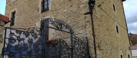 A stone building with a metal gate and a sign that reads "CENTRO TURISCALE."