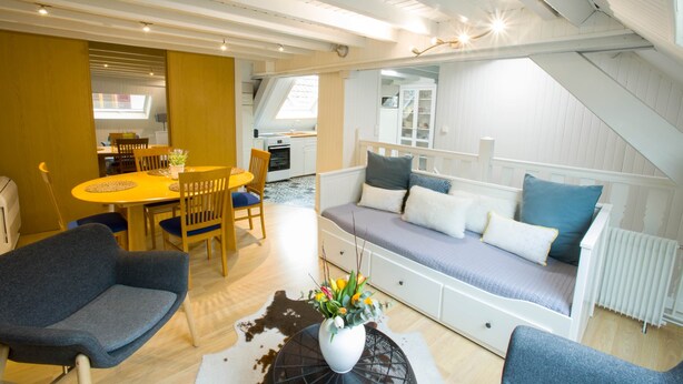 A modern loft apartment with a dining area, a sofa, and a kitchen. - Les Tournesols **, 2-bedroom 2-bathroom apartment in the historic heart of Kaysersberg (Kaysersberg-Vignoble)