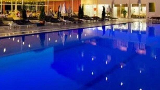 A hotel with a swimming pool, multiple floors, and a mountain backdrop. - Castle Park Hotel (Kemer)
