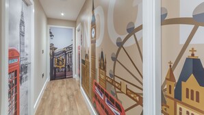 A hallway with a wall mural depicting iconic London landmarks like Big Ben and the London Eye. - The Old School House & Rooms- The Lace Market  (Nottingham)