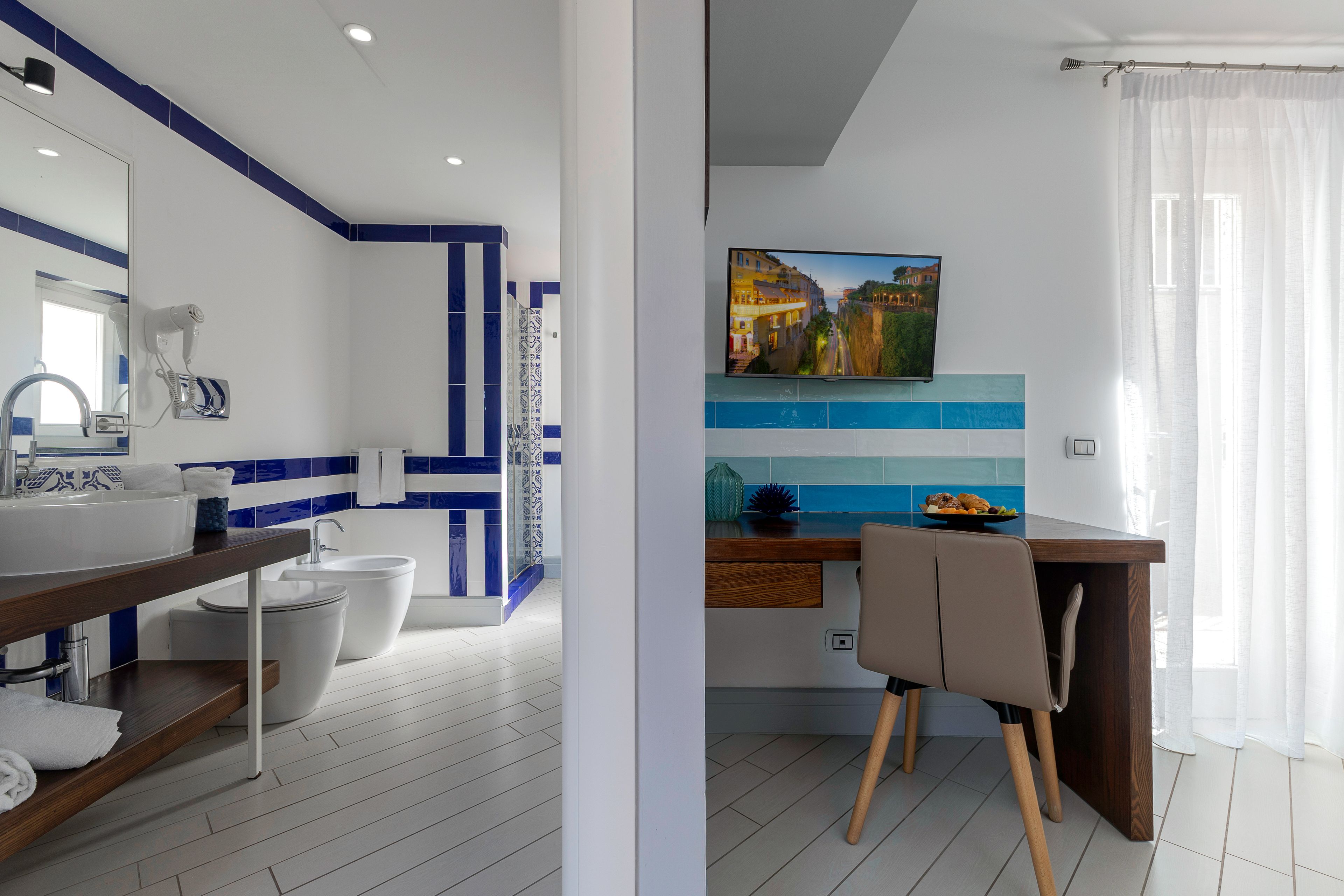 A modern bathroom with a white sink, a hairdryer, and a toilet.
