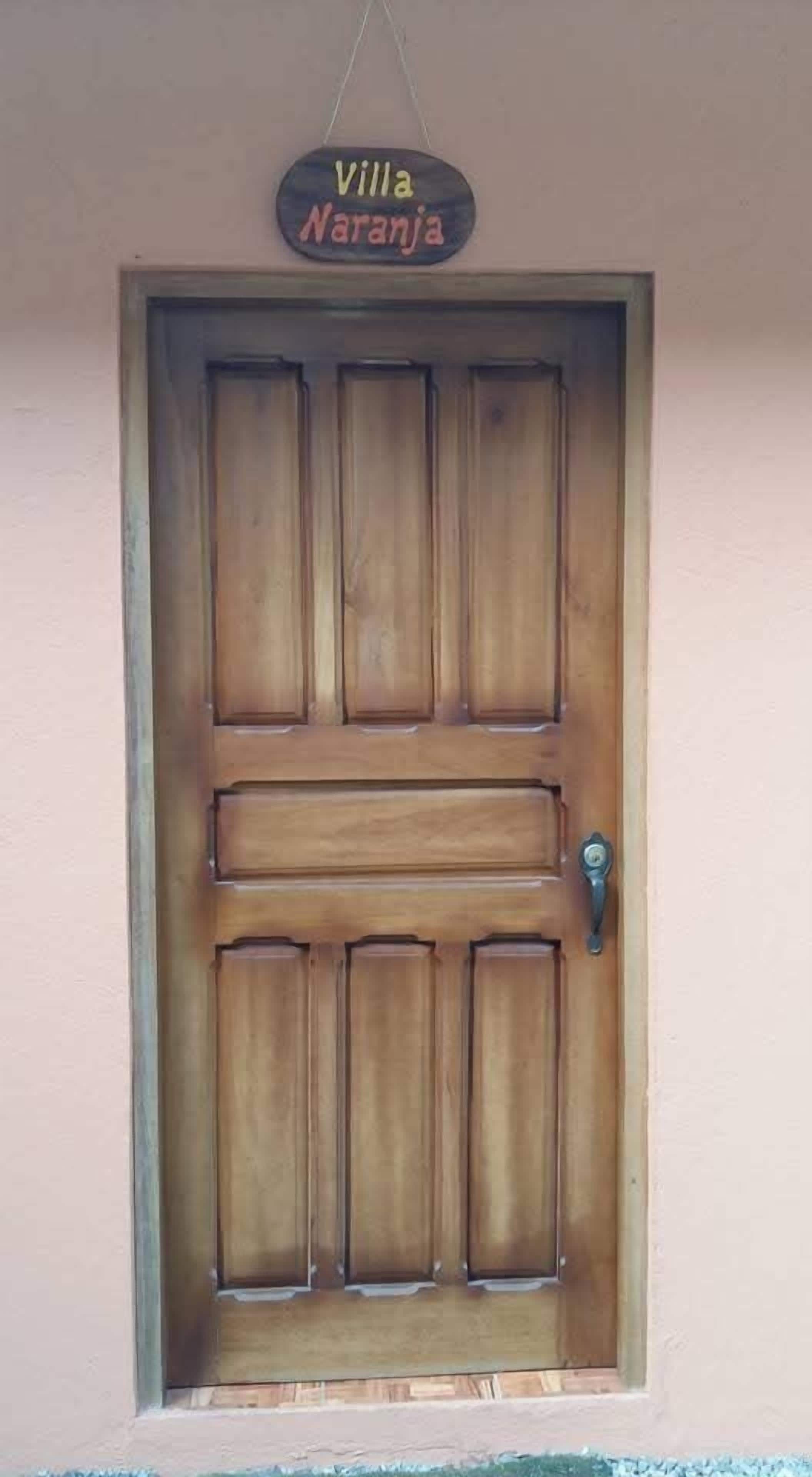 Una puerta de madera con un cartel encima que dice "Villa Naranja".