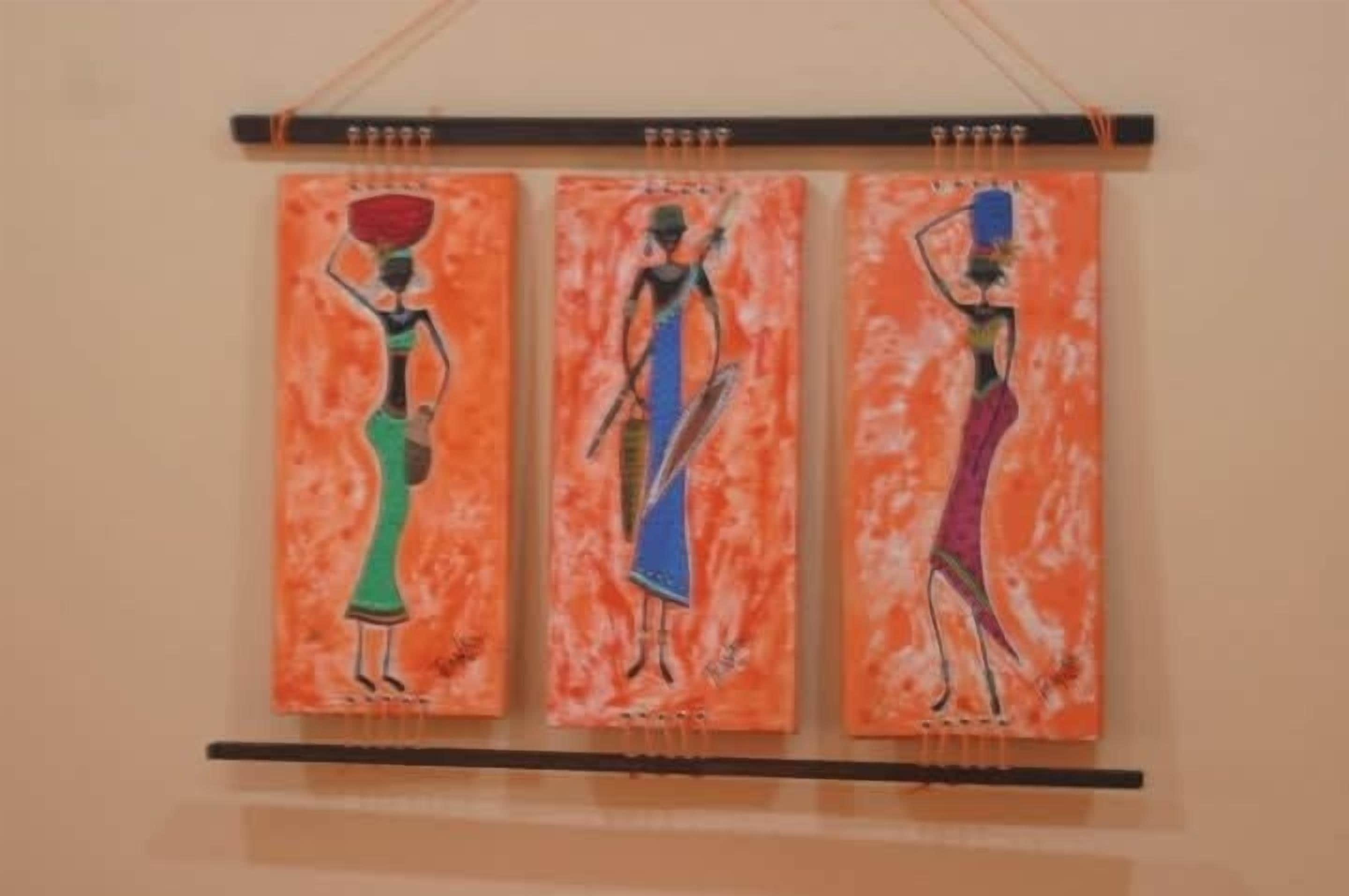 Drie schilderijen van figuren op een oranje achtergrond.