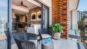 A modern living area with wicker furniture, a ceiling fan, and a potted plant. - Perfect, freshly decorated one bedroom Loft 268! (Puerto Vallarta)