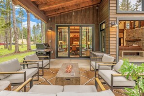 An outdoor patio with modern furniture, a fire pit, and a view of a forested area. - 5 Star Luxury Crafted for Family Memories | Spa/Epic GameRm+ 1PM Check In/Out (Cle Elum)