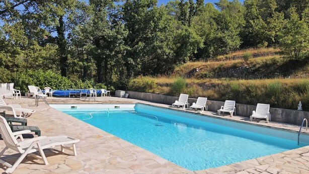 A rectangular swimming pool with a stone deck and lounge chairs. - La ferme de Manon les Lavandes in an 18th century farmhouse (MONTFERRAT)