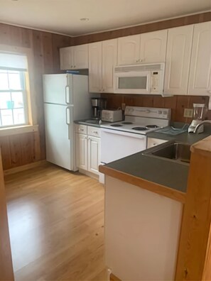Enjoy cooking in this well-equipped kitchen with a refrigerator, microwave, stove, and sink.
