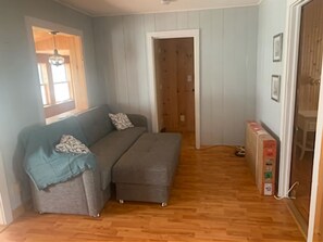 Cozy retreat with a sofa, ottoman, and access to another room.