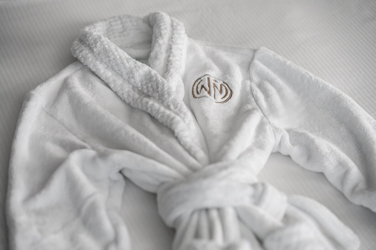 A white robe with a monogram on a textured surface.