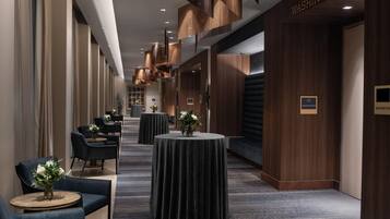 A hotel corridor with round tables, chairs, and a sign reading 'WASHINGTON'.