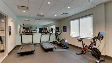 A fitness center with treadmills, elliptical machines, and a stationary bike.