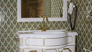A bathroom with a white vanity, gold trim, and a mirror above the sink. - Palatul Brukenthal Avrig (Avrig)