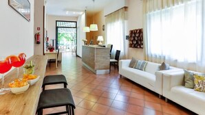 A modern hotel room with a dining area, a sofa, and a reception desk. - Hotel Avana Mare (Rimini)