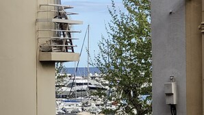 Un port de plaisance avec des bateaux amarrés, un banc et un panneau indiquant « Yachts et activités nautiques ».