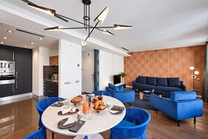 A modern living room with a sofa, a dining table set with plates, glasses, and a pitcher of orange juice. - Sweett | Palau II - Two Bedroom Apartment, Sleeps 6 (Barcelona)