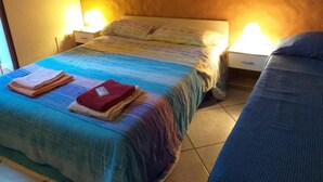 A bedroom with a bed, two bedside tables, and a wall-mounted artwork.