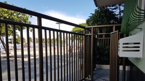 Une entrée fermée par un portail et une clôture en métal, un banc et un mur recouvert de carreaux.