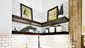 Una cocina moderna con armarios blancos, un lavamanos de acero inoxidable y lavavajillas integrado.