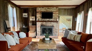 Una sala de estar acogedora con dos sofás, una chimenea y un televisor.