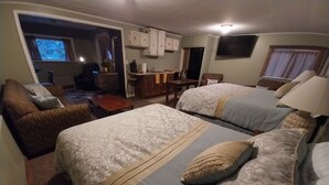 Une chambre d’hôtel avec deux lits, un canapé, un bureau et une télévision.