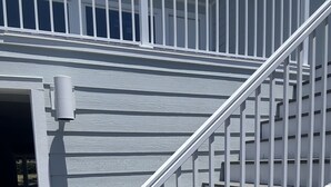 A staircase with white railings and wooden steps leading to an upper level.