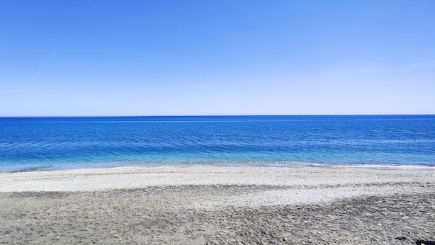A beach with clear blue water and a sandy shore. - AP346 TORROX BEACH (Torrox Costa)