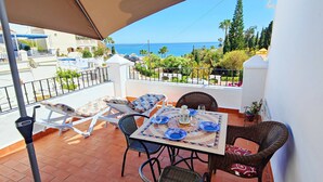 A balcony with a table set for two, chairs, and a view of the sea. - AP346 TORROX BEACH (Torrox Costa)