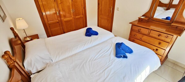 Ein Hotelzimmer mit Bett, Holzschrank, Kommode und Spiegel.