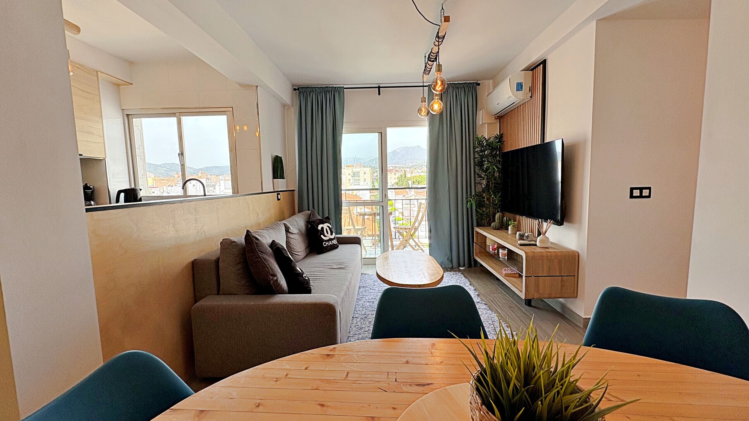 Een moderne woonkamer met een bank, een eettafel en een televisie.