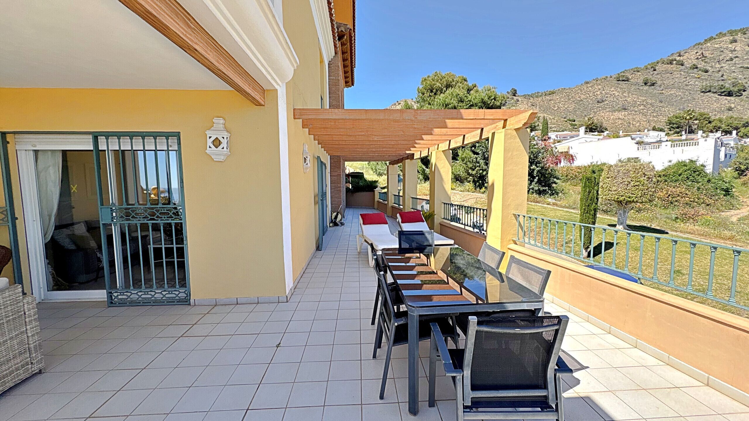 Un espace extérieur abrité doté d’une terrasse, d’une piscine et offrant une vue sur une colline.