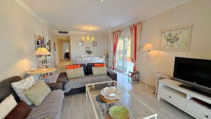 A living room with a sofa, coffee table, TV, and a dining area in the background. - AP191 SEÑORIO DE CAPISTRANO (Nerja)