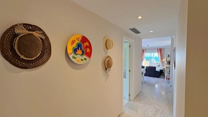 A hallway with decorative hats on the wall, leading to a room with a view of the sea. - AP191 SEÑORIO DE CAPISTRANO (Nerja)