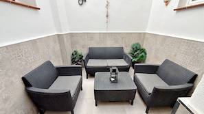 A corner seating area with a sofa, two armchairs, and a small table.