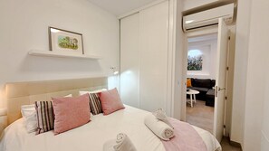 A neatly made bed with pillows, a bedside lamp, and a framed picture on the wall.