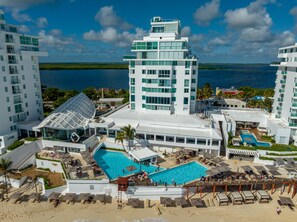 Een resort met meerdere gebouwen, een centraal gelegen zwembad en een strand.