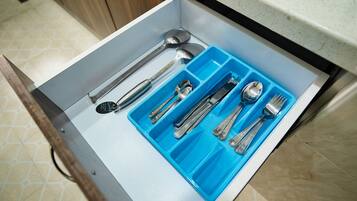 A drawer with compartments containing various kitchen utensils.