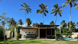 A house with a patio, a pool, and palm trees.