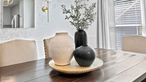 A dining table with a vase and a bowl on a wooden tray, a mirror, and a wall with a floral pattern. - The best of Huntsville: Mountain view & Attraction. (Huntsville)