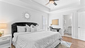 A bedroom with a large bed, a ceiling fan, a bedside table with a lamp, and a mirror on the wall. - The best of Huntsville: Mountain view & Attraction. (Huntsville)