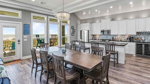 Una cocina amplia con armarios blancos, una isla grande y vistas al exterior.