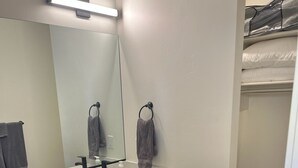A bathroom with a wooden vanity, a mirror, a towel rack, and a black rug. - Cozy Casita by Sand Hollow and Zion (Hurricane)