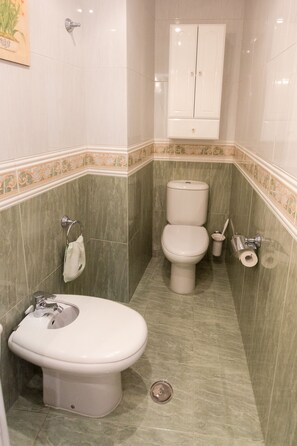 A bathroom with a toilet, bidet, and sink. - House Goros II (Melide)
