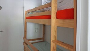 Un lit superposé avec un matelas rouge et une structure en bois.
