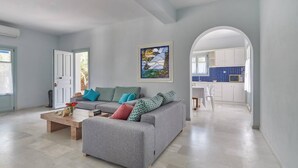 Una sala de estar moderna con un sofá gris, una mesa de centro y un cuadro en la pared.