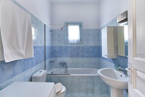A bathroom with a bathtub, toilet, and sink. - Aegean Villa in Paros (Paros)