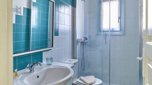 A bathroom with a sink, mirror, toilet, and shower. - Santa Maria Villa in Paros (Paros)