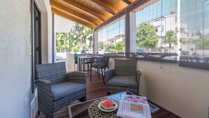 A covered outdoor seating area with wicker furniture and a table with a watermelon slice.