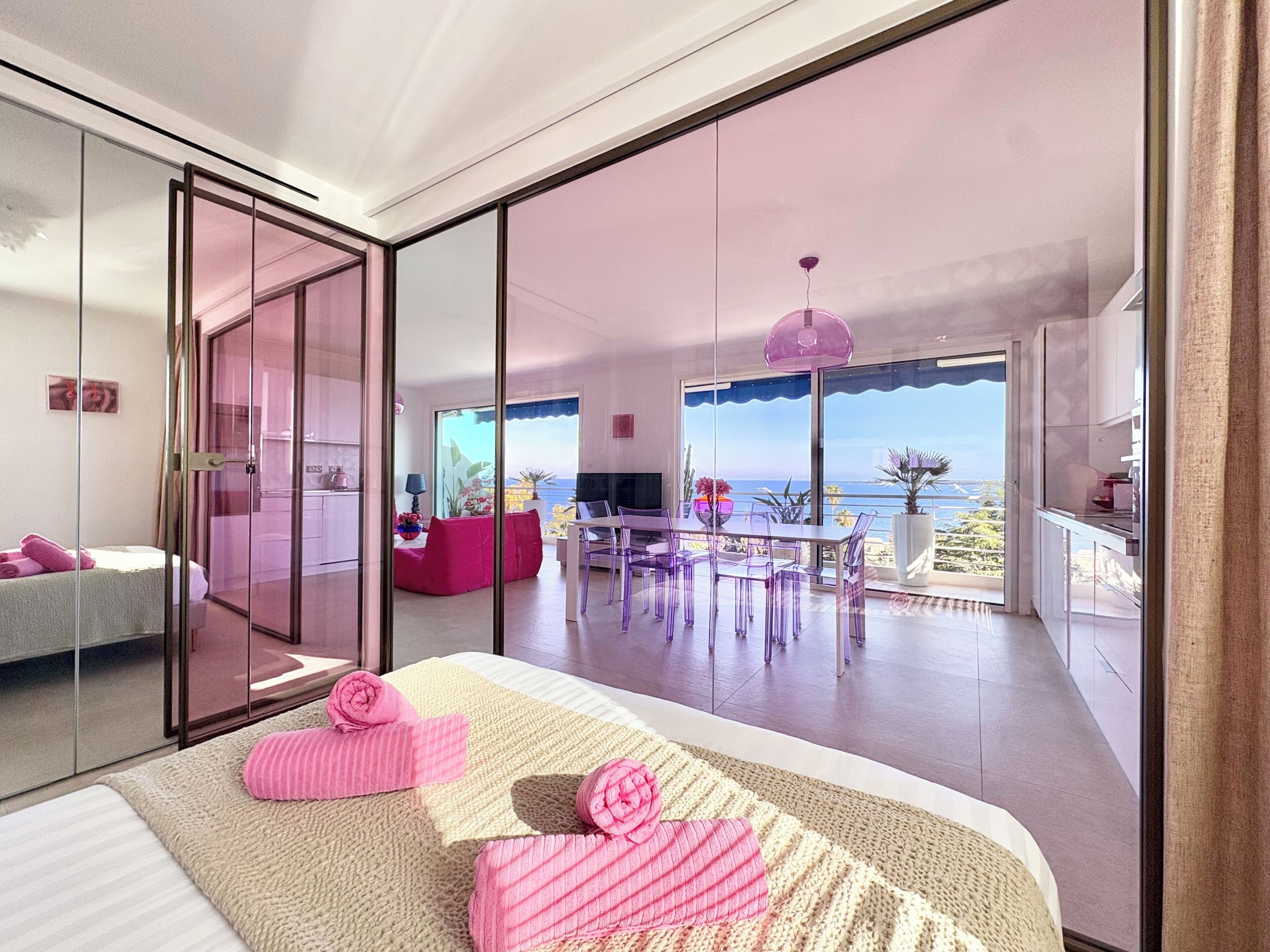 Ein modernes Schlafzimmer mit einem großen Bett, einem Balkon mit Aussicht und einem Essbereich.