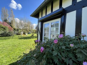 Una casa con un giardino antistante, un prato e un cielo sereno.